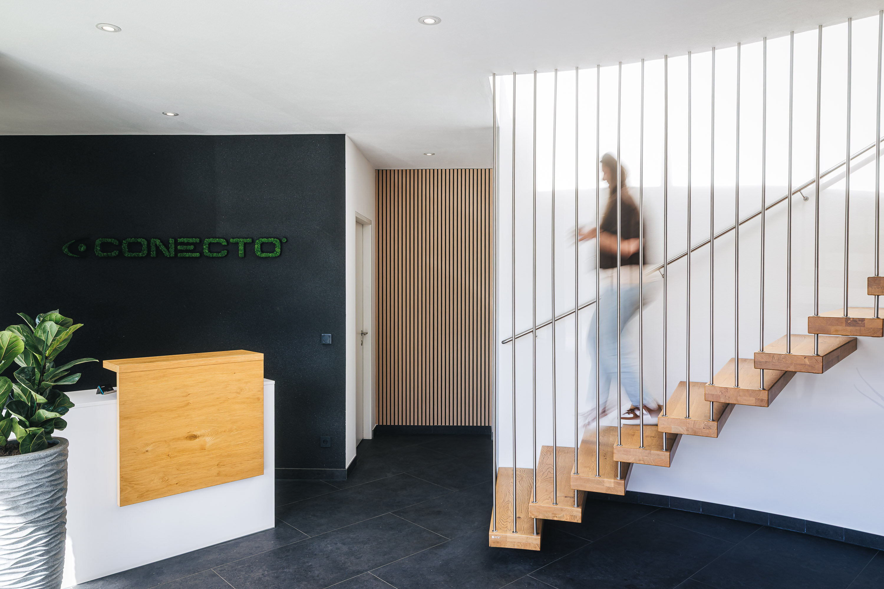 Mitarbeiterin geht die Treppe zum Eingangsbereich hinunter | © Johannes Radlwimmer
